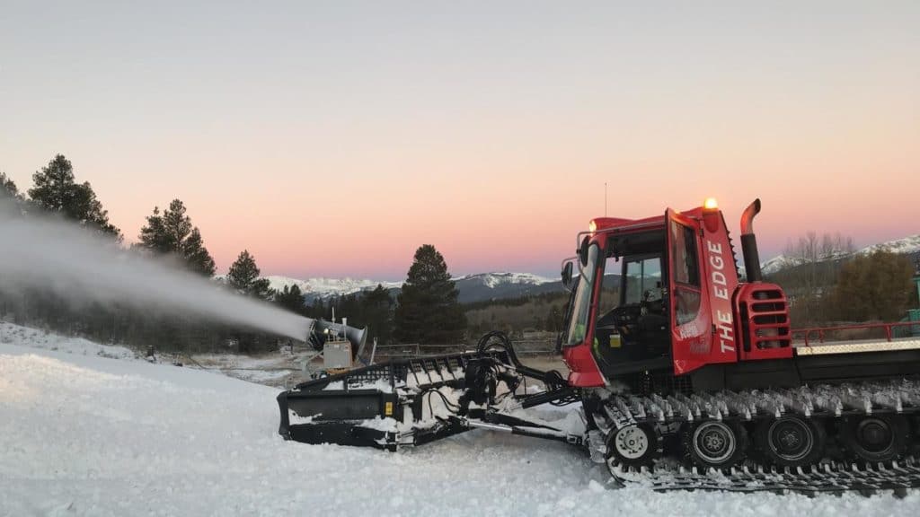 Colin Whitaker, Ski Area Ops graduate at COlorado Mountain College Leadville, operating a snocat during a Colorado sunset. He landed a full-time job at Killington Resort this past spring.