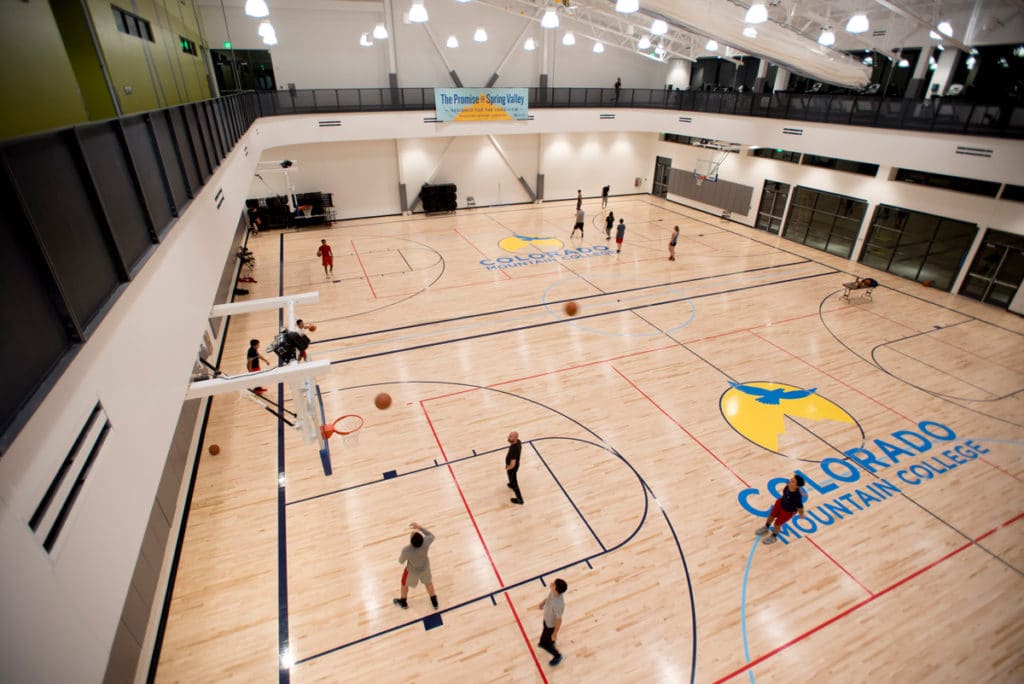 Students and community members play basketball on the two-court floor of the CMC Spring Valley Outdoor Leadership Center & Field House.