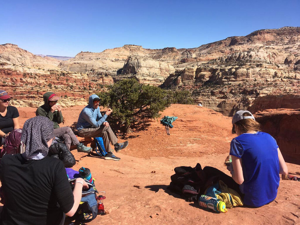 CMC Outdoor Education students and instructors break for lunch and laugh during a desert orientation trip.