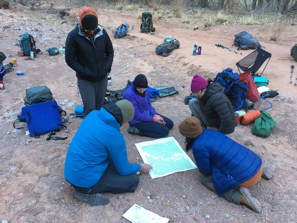 CMC Outdoor Education instructor teaches map reading in the field during a desert orientation trip.