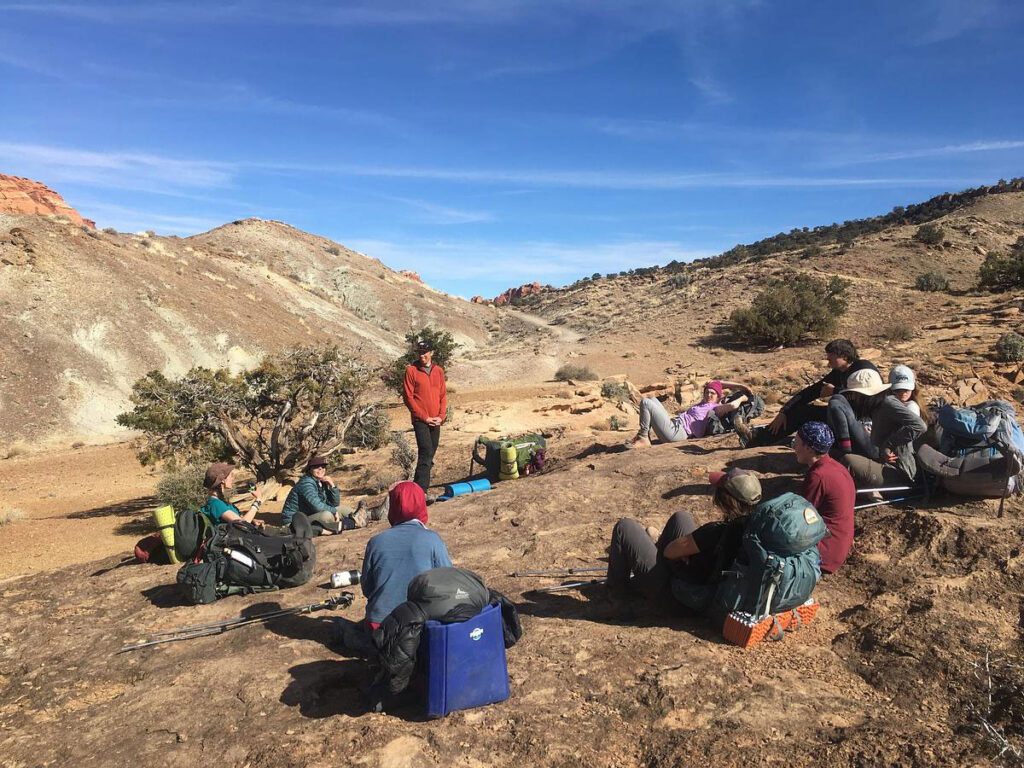 CMC Outdoor Education instructor teaches a class a slick rock overlook a desert orientation trip.