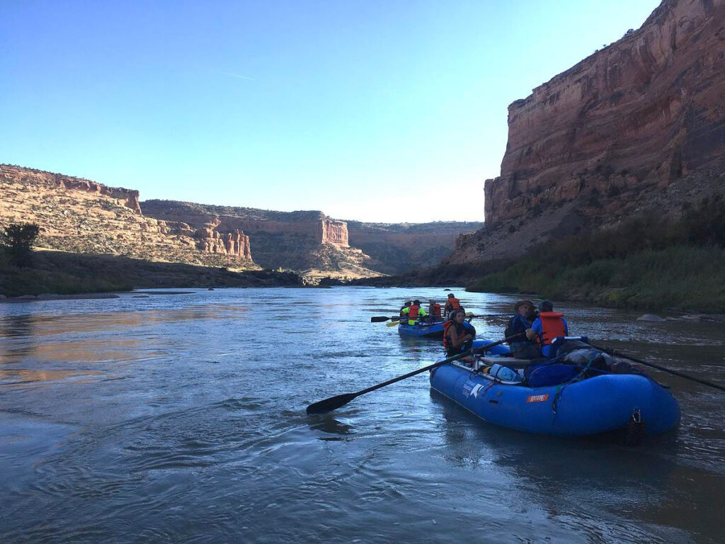 CMC Outdoor Education rafting class foating below high canyon walls..
