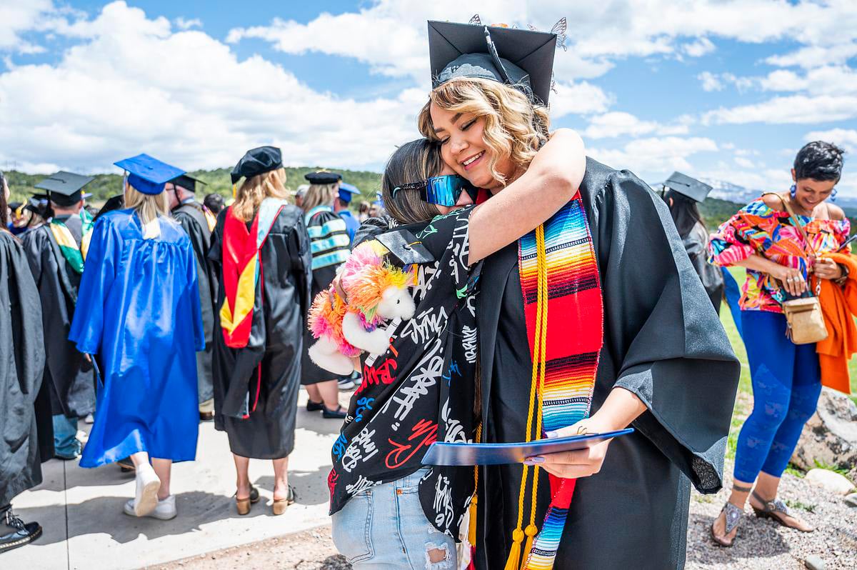 CMC graduate receives a hug following commencement at CMC Spring Valley
